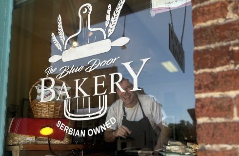 store front window with bakery logo and loaves of bread