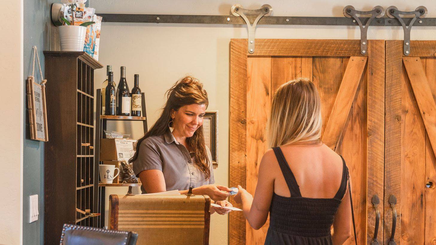 guest checking into hotel and hotel staff handing keys to guest