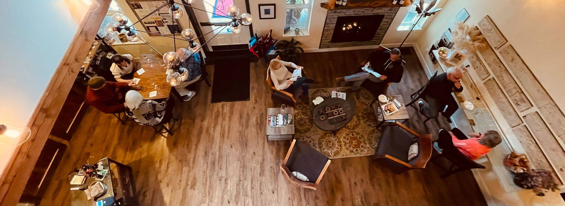 looking down into lobby with groups of people at tables and lounge chairs visiting and toasting